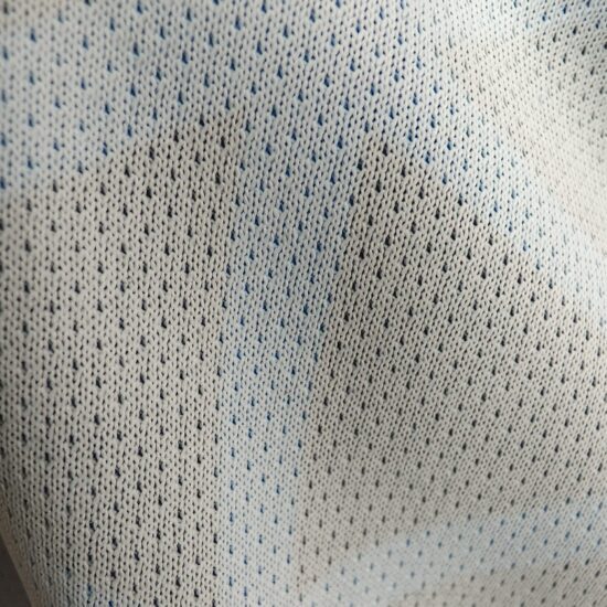Close-up of a textured white fabric with small perforations.