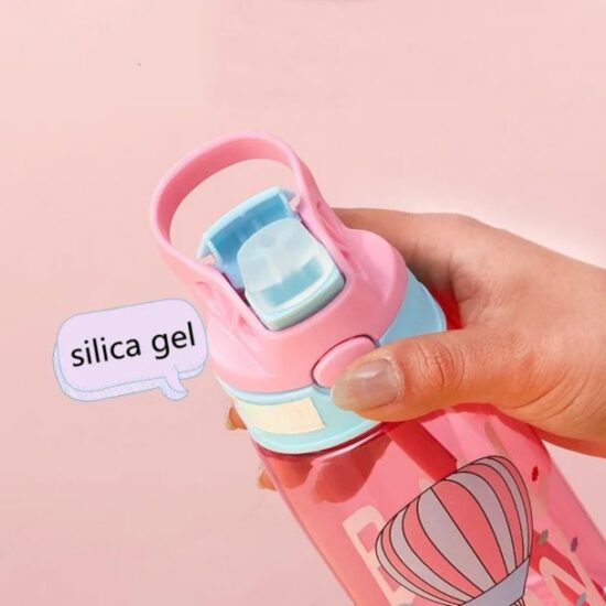 Hand holding a pink water bottle with a silicone spout and silica gel label.