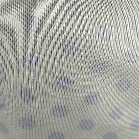 Close-up of light fabric with blue polka dots.